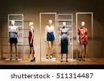 Five Mannequins Standing In Store Window Display Of Women's Casual Clothing Shop In Shopping Mall.