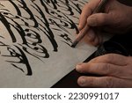 A calligrapher writing with pen ...