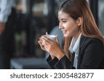 Small photo of Banner of Asian woman Proprietor holding hot coffee in white ceramic cup to sniff smell of espresso in office work place . business owner entrepreneur girl carry coffee break to sniff fragrant smell