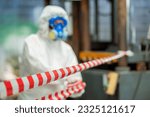Small photo of Man inspector scientist investigate chemical gas leak spill with safety face mask PPE suit in area closed barricade security red white tape. danger area infected toxic leak spill cross stripe ribbon