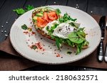 Small photo of Bruschetta with sliced avocado, feta cheese, pesto sauce, poached egg and salted salmon. Healthy and wholesome food. Serving food in a restaurant