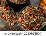 Small photo of Small pieces of dried vegetables in jar , dry celery, dry ccarrot and dry onion. Mix of spices. Spice shop.