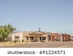 Small photo of Part of Route 66 with a former service station on the corner and other businesses along the main drag of a one way street in a small town