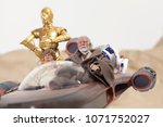 Small photo of APR 17 2018: Recreation of a scene from Star Wars A New Hope; Luke Skywalker, Obi Wan 'Ben' Kenobi and the droids R2D2 and C3P0 riding in a X34 Landspeeder on Tattooine - Hasbro Black Series figures