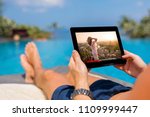 Man watching movie on tablet by the pool.