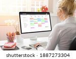 Woman using calendar on computer to organize her schedule at work