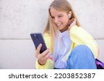 Girl using mobile phone and listening to music