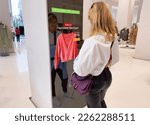 Small photo of Woman viewing advanced mirror display in retail store showing personalized offers to customers