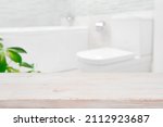 Modern blurred bathroom background with wooden table top in front