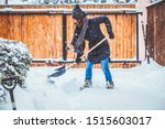 woman with shovel cleaning snow. Winter shoveling. Removing snow after blizzard