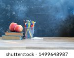 Back to school concept with colorful school supplies with aaple friuts on blackboard background with copy space on blackboard