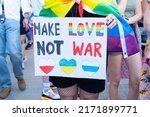 Gay pride parade, someone with make love not war poster