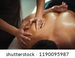 Physiotherapist massaging male patient with injured shoulder blade muscle. Sports injury treatment.
