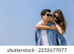 Small photo of Portrait of beautiful caucasian woman with man wearing sunglasses swim suit piggy back on beach. Young couple enjoy honeymoon after marriage sea. Happy casual lover hold at the tropical beach