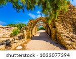 Sunny spring day. Arched passage - covered street. Picturesque ruins of the ancient seaport Caesarea. Israel. Concept of ecological and historical tourism