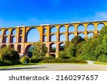 Small photo of The train passes over the bridge. The Goltzsch Viaduct is the world's largest brick viaduct. Sunny cold morning in October. Germany.