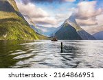Tourist boat in the smooth water of the Milford Sound. New Zealand. South Island. Fiordland park. The magical nature of the southern hemisphere. 