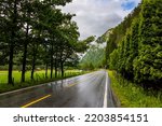 Small photo of The rain-wet highway glitters in the fog. Lush clouds and constant cold rain. Scenic road in the mountains of Western Norway. Norway. Scandinavia. Summer, July