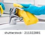 Woman doing chores in bathroom, cleaning of water tap