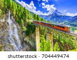 Zermatt, Switzerland. Gornergrat tourist train with waterfall, bridge and Matterhorn. Valais region.