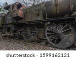 Small photo of Rusty old steam locomotive with rivets and big wheels