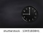 Small photo of Black wall clock showing nine o'clock on black chalkboard background. Office clock showing 9am or 9pm on black texture