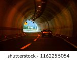 Small photo of Left two lines curved highway tunnel with one car driving on the right line to the exit on the end.