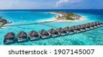 Small photo of Aerial view of Maldives island, luxury water villas resort and wooden pier. Beautiful sky and ocean lagoon beach background. Summer vacation holiday and travel concept. Paradise aerial landscape pano