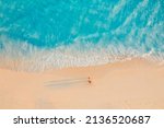 Aerial view of amazing beach with couple walking in sunset light close to turquoise sea. Top view of summer beach landscape, romantic inspirational couple vacation, romantic holiday. Freedom travel
