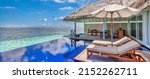 Small photo of Luxury beach resort, bungalow near endless pool over beautiful blue sea. Amazing tropical island, summer vacation concept. Couple chairs with umbrella, perfect summer leisure vacation holiday panorama