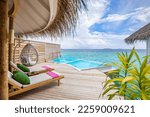 Fantastic over water villa, terrace view with sun beds chairs under umbrella, luxury pool hotel with stunning ocean view. Beautiful spa or wellness concept, recreational vacation resort tranquil area

