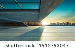 Small photo of Perspective view of empty concrete floor and modern rooftop building with sunset cityscape scene. Mixed media