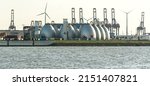 Gas storage reservoir, wind turbines and cranes in the harbour area in Hamburg, Germany 