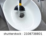 Small photo of Clogged sink in house - unclog the blockage with sink plunger.