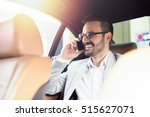 Handsome businessman using mobile phone in car. Happy face.
