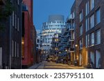 Small photo of Copenhagen, Denmark - 06 OCTOBER 2022: Outdoor night street diminishing perspective view among residential buildings toward famous office building "Portland Towers Corporate Offices".
