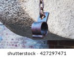 Small photo of Old rusty medieval shackles on chain in place of the execution of heretics in Gdansk, Poland.