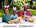 Small photo of Portrait of happy african american siblings and grandparents in bunny ears painting easter eggs. unaltered, lifestyle, easter day, art, celebration, family, cultures and holiday concept.