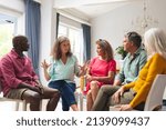 Small photo of Caucasian senior woman discussing with multiracial people during group therapy session. unaltered, support, alternative therapy, community outreach, mental wellbeing and social gathering.