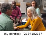 Small photo of Caucasian senior man and woman talking during group therapy session. unaltered, support, alternative therapy, community outreach, mental wellbeing and social gathering.