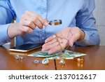 Small photo of Pawnshop worker verify jewellery and photo or video camera and give money. Customers Buy and Sell Precious Metals, Jewels, Ancient Coins and Second Hand Electric Appliances. Closeup