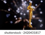 Small photo of Hollywood Golden Oscar Academy award statue on fireworks background with copy space. Success and victory concept.
