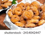 Small photo of Basket with delicious fatti fritti, traditional fried donuts produced in Sardinia, typical carnival dessert, Italian food
