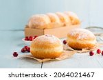 Small photo of Hanukkah sweet food doughnuts sufganiyot with powdered sugar and fruit jam on blue wooden background. Jewish holiday Hanukkah concept.
