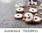Traditional Christmas Linzer cookies with raspberry jam on dark background.  Austrian biscuits filled. Selective focus Copy space. Holiday concept