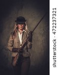 Small photo of Lady with shotgun from wild west on dark background.