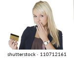 Small photo of Beautiful blonde woman with a guilty look and her hand to her mouth holding up her credit card on which she has gone on a spending spree and overspent