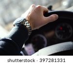 A man drives a car. Close-up of man's hand on steering wheel. Shallow depth of field.