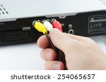 Hand connecting AV cables to AV Receiver