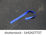 Small photo of Elastic Tie Off Used for Drug Injection Discarded on City Street